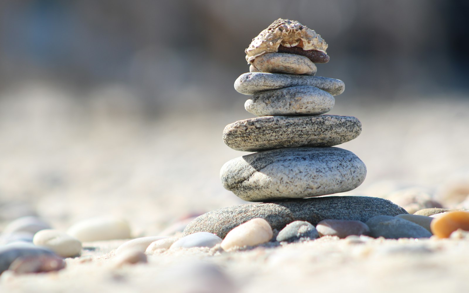 A stack of balanced stones on a sandy beach