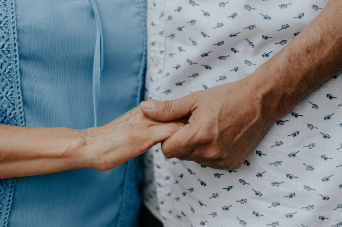A woman holding her mother's hand