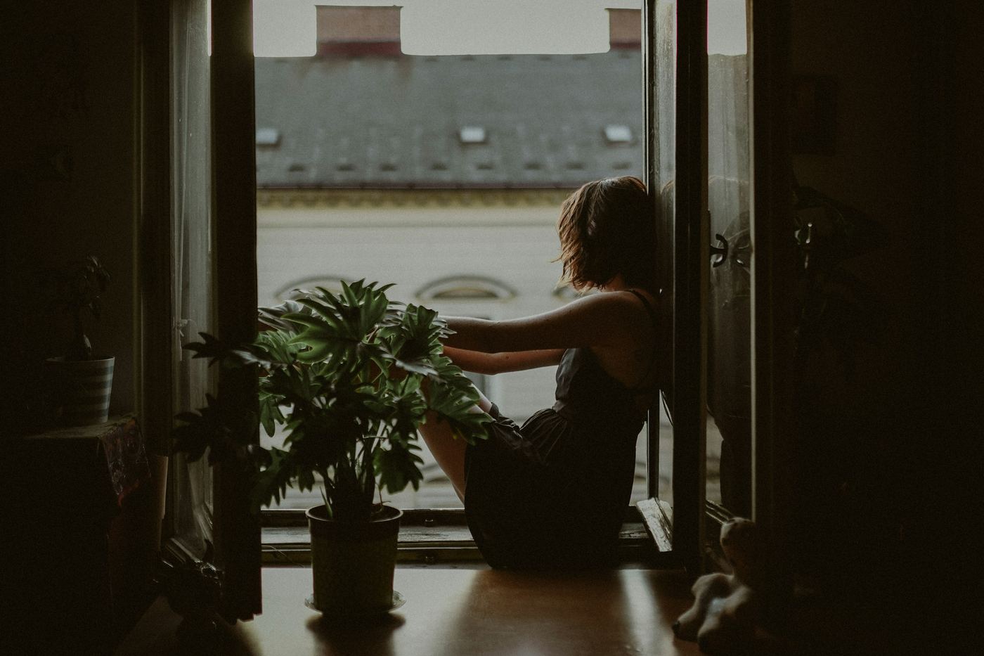 A woman sitting alone in a doorway, looking out